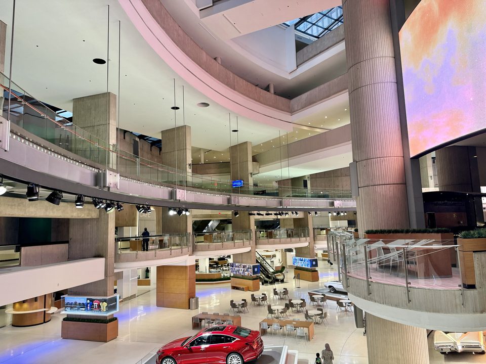 The stacked galleries and concrete piers of the central atrium in 2024, with a display car below