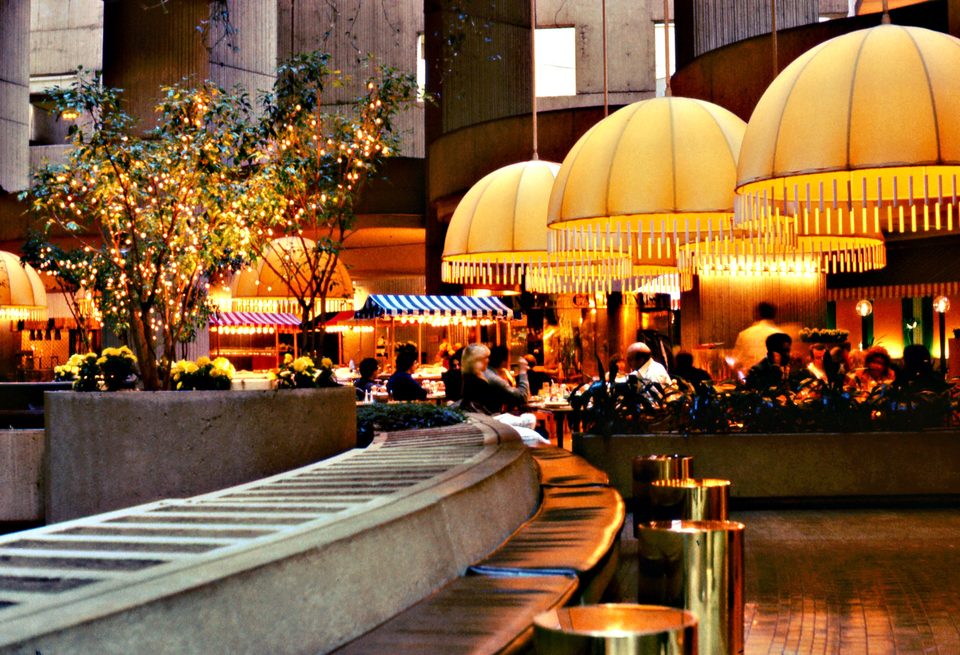 A restaurant under yellow umbrella-shaped lamps in the central atrium, 1984