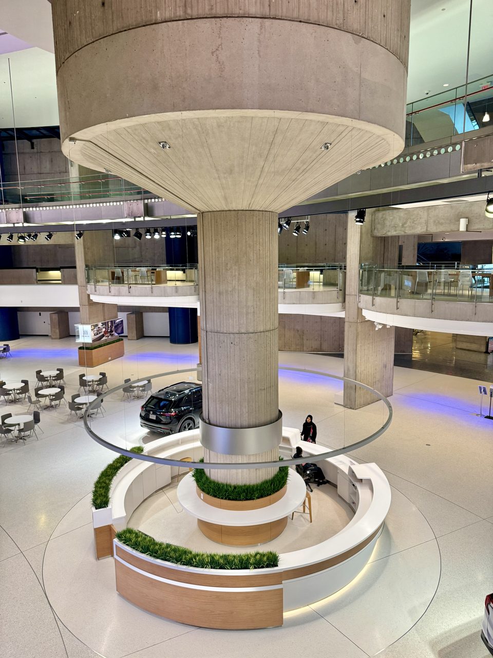 One of Portman’s signature concrete columns with its cup-shaped crown and a round desk at its foot in the central atrium (2024)