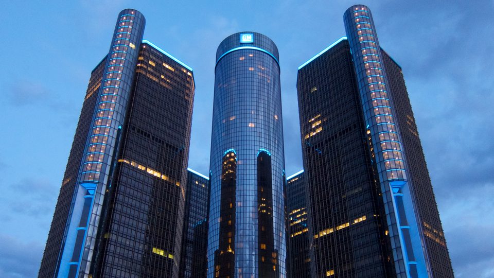 The towers glowing at blue hour in March 2013, with blue light strips on the hotel cylinder and the office tower edges