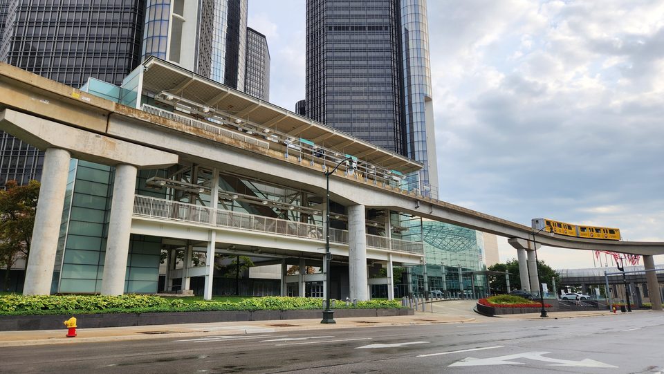 The People Mover’s Renaissance Center station from Jefferson Avenue in August 2025, with a yellow train arriving on the right