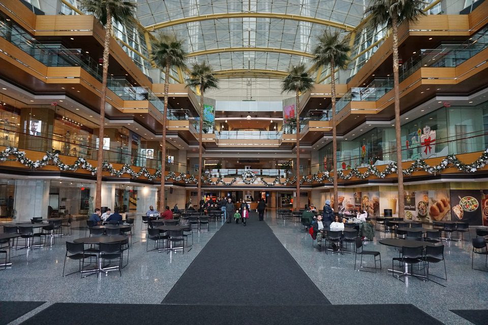 The five-story glass hall of the Wintergarden with palms, tables and holiday garlands, December 2015