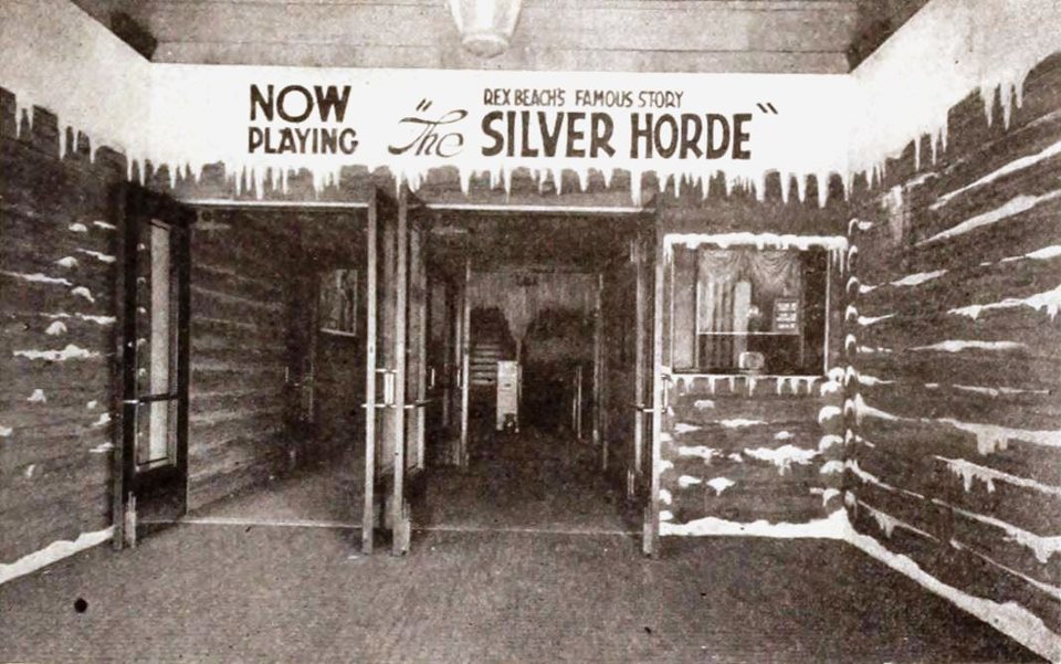 Az Adams Theatre bejárata 1920-ban, havas gerendaháznak díszítve a The Silver Horde vetítésére, NOW PLAYING felirattal