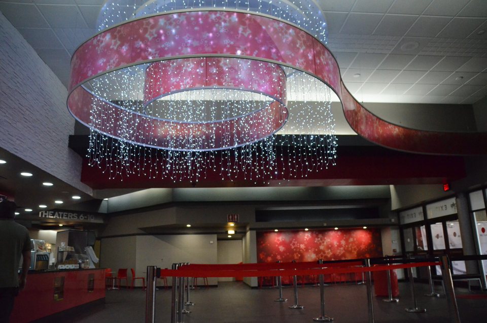 The Bel Air lobby with a huge glowing red ribbon chandelier, red queue ropes and the THEATERS 6-10 sign