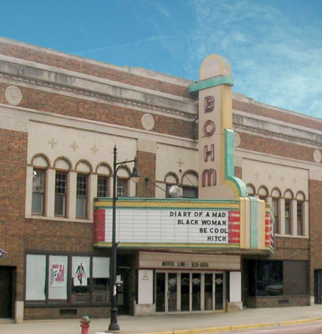 The Bohm Theatre's brick facade with its vertical BOHM sign and letterboard marquee by day