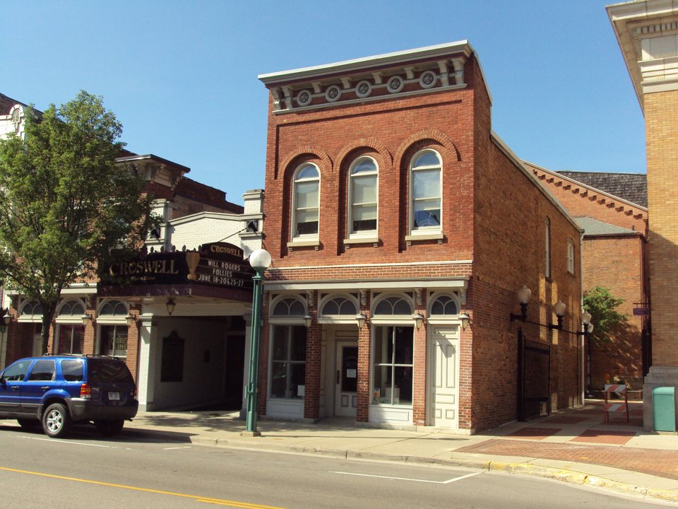 The Croswell Opera House street front by day, with its old black marquee announcing The Will Rogers Follies beside a red-brick building