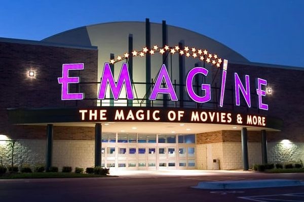 The lit purple EMAGINE sign and the 'The Magic of Movies & More' canopy at dusk