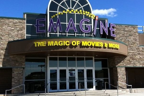 The Emagine Rochester Hills entrance by day, with purple letters in front of an arched window and a canopy in yellow lettering