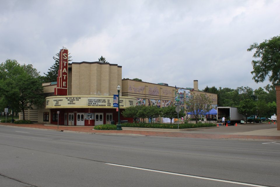 The State Wayne's red vertical STATE sign, curved marquee and mural-covered side wall on Michigan Avenue