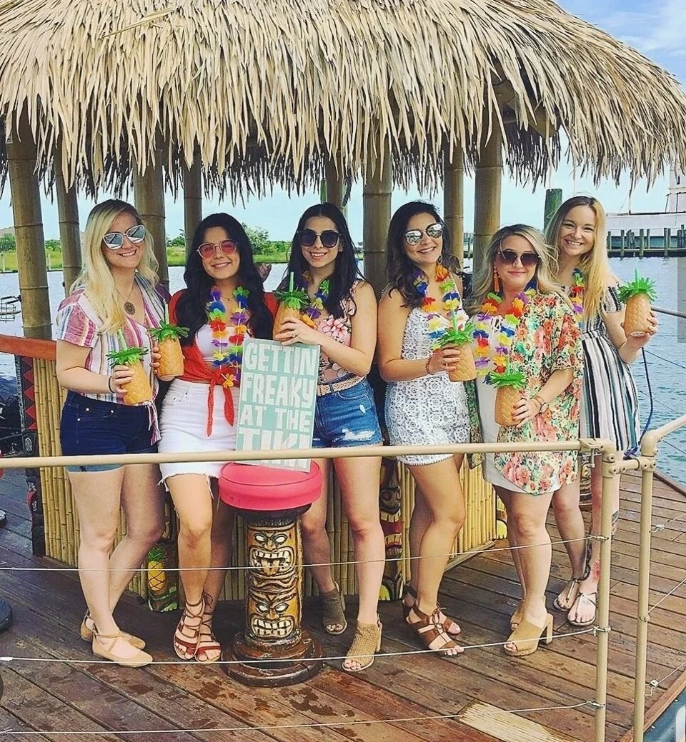 A cheerful group drinks under the thatched roof of the Detroit tiki bar boat