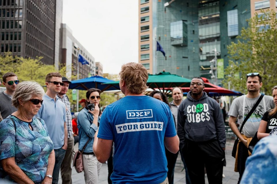 Az idegenvezető a csoportnak magyaráz Detroit belvárosában