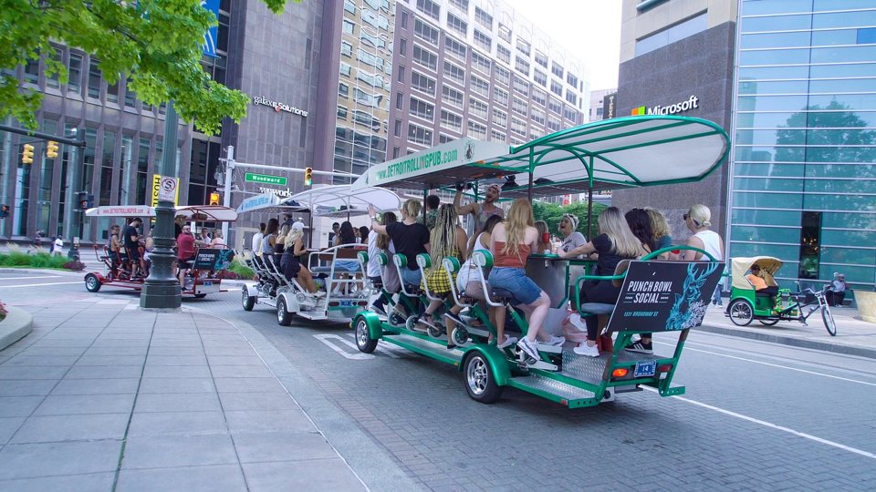 The pedal-powered bar rolls down Woodward Avenue with the Microsoft office behind it