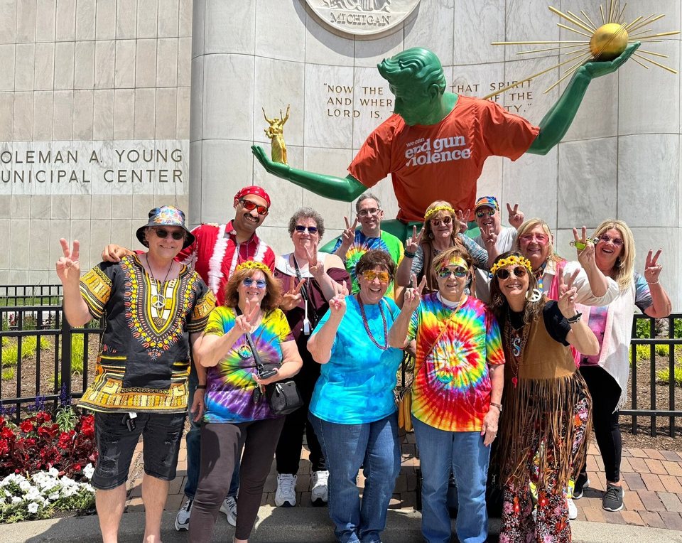 A costumed group poses at the Spirit of Detroit statue by the Coleman A. Young Center