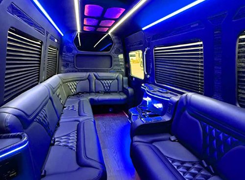 Blue LED-lit bench seating and a small table inside the party bus