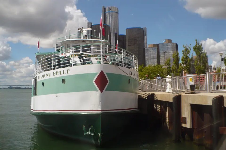 A Diamond Jack's boat at the Detroit riverfront, with the downtown towers behind it