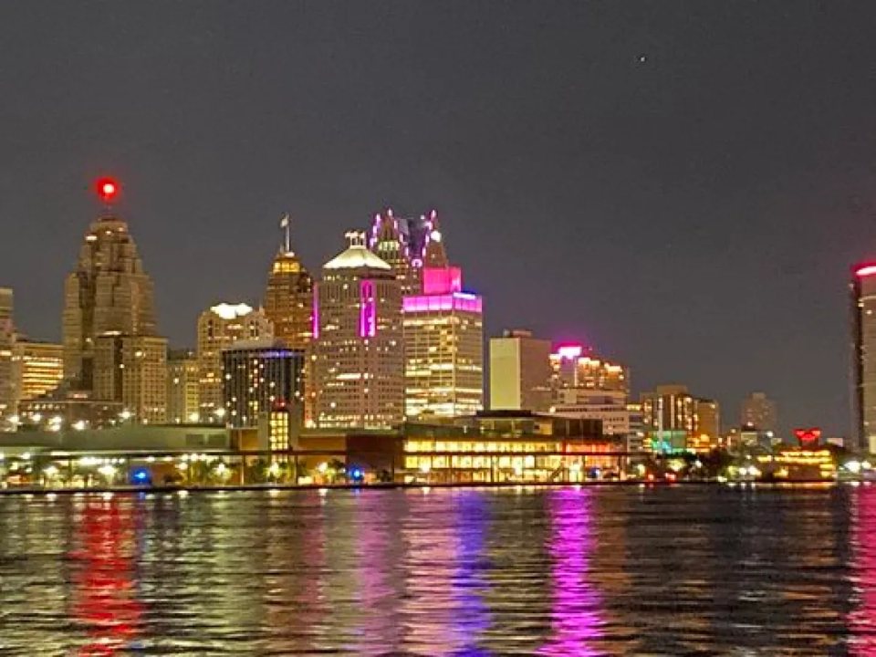 Detroit's lit-up downtown skyline seen from the river during an evening cruise
